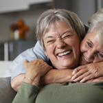 elderly woman holding younger woman