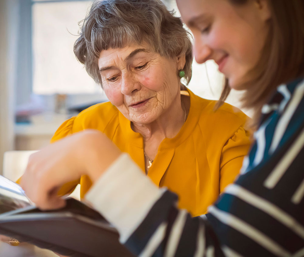Woman reading with elderly woman